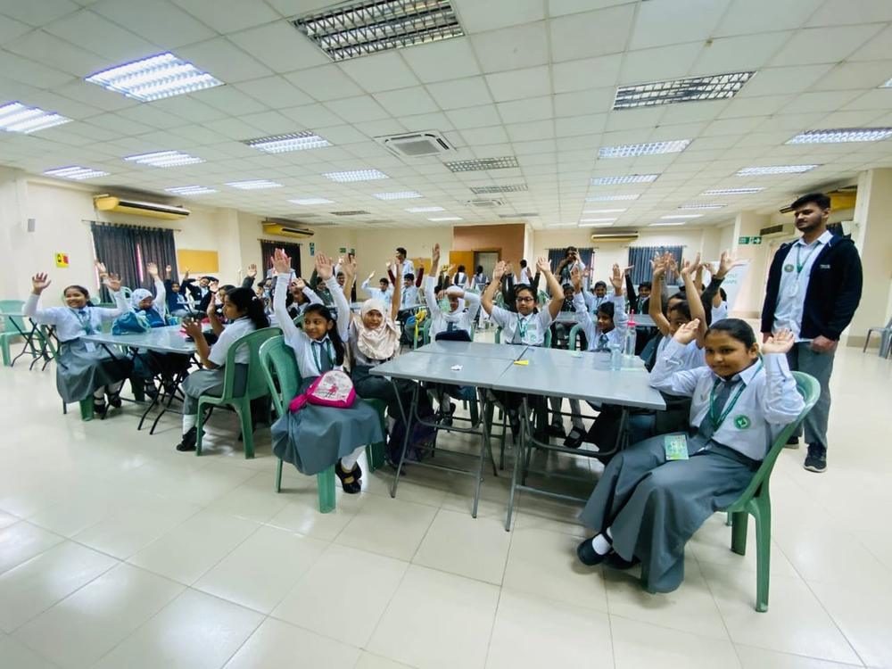 Primary school children raising hands during a Kids for Nature session